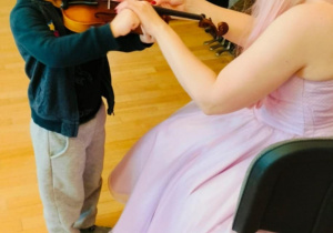 Chłopiec próbuje grać na skrzypcach