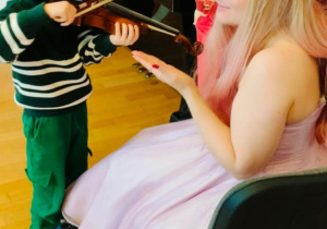 Chłopiec próbuje grać na skrzypcach