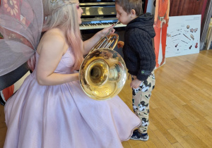 Chłopiec próbuje grać na puzonie