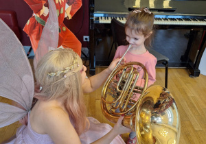 Dziewczynka próbuje grać na puzonie