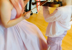 Dziewczynka próbuje grać na skrzypcach