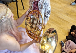 Dziewczynka próbuje grać na puzonie