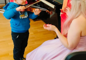 Chłopiec próbuje grać na skrzypcach