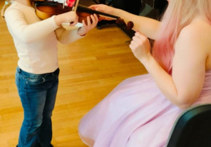 Dziewczynka próbuje grać na skrzypcach
