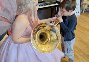 Chłopiec próbuje grać na puzonie