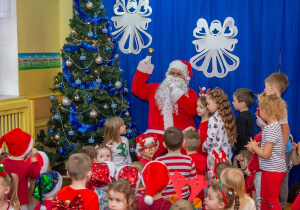 Dzieci siedzą obok Świętego Mikołaja