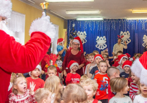 Dzieci naśladują ruchy animatorki i Świętego Mikołaja podczas wspólnej zabawy