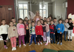 Grupa dzieci z wróżką pozuje do zdjęcia