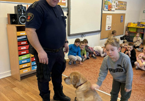 Strażnik miejski i chłopiec głaszczący psa