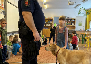 Strażnik miejski i dziewczynka głaszcząca psa