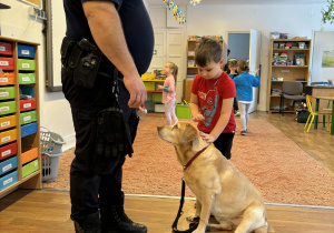 Strażnik miejski i chłopiec głaszczący psa