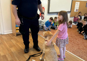 Strażnik miejski i dziewczynka głaszcząca psa