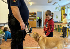 Strażnik miejski i chłopiec głaszczący psa