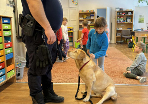 Strażnik miejski i dziewczynka głaszcząca psa