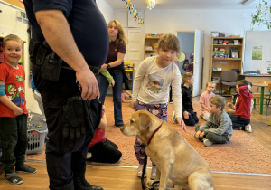 Strażnik miejski i dziewczynka głaszcząca psa