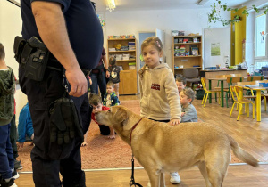 Strażnik miejski i dziewczynka głaszcząca psa