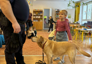 Strażnik miejski i dziewczynka głaszcząca psa