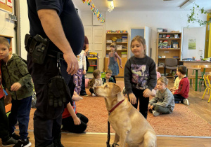 Strażnik miejski i dziewczynka głaszcząca psa