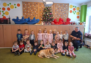 Dzieci pozują do zdjęcia ze strażnikiem i jego psem