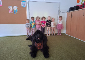 Dzieci pozują do zdjęcia z psem