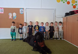 Dzieci pozują do zdjęcia z psem