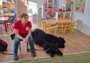 Prowadząca zajęcia opowiada dzieciom o dogoterapii