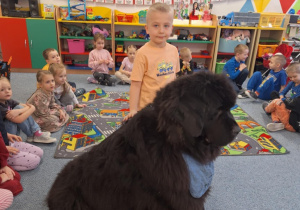 Chłopiec głaszcze siedzącego psa