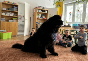 Duży pies siedzi prze dziećmi