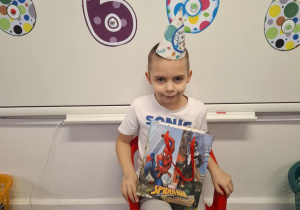 Solenizant siedzi na krzesełku i pozuje do zdjęcia