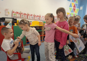 Grupa dzieci składa solenizantowi życzenia