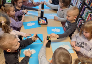 Grupa dzieci wykonuje prace plastyczną - bałwanka