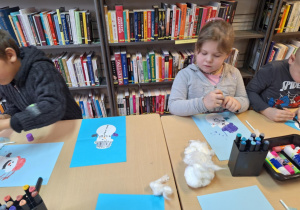 Grupa dzieci wykonuje prace plastyczną -bałwanka