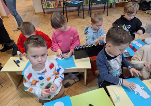 Grupa dzieci wykonuje prace plastyczną -bałwanka