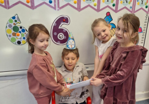 Grupa dziewczynek wręcza Julkowi laurki