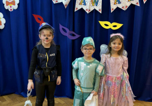 Dwie dziewczynki i chłopiec w przebraniach karnawałowych