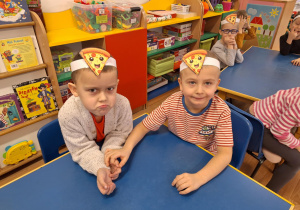 Chłopcy siedzą przy stole i pozuje do zdjęcia