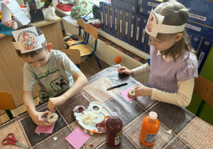 Chłopiec i dziewczynka wykonują pracę plastyczną