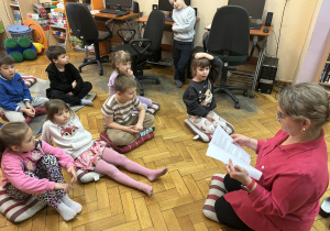 Pani bibliotekarka czyta dzieciom książeczkę