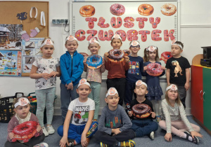 Dzieci stoją na dywanie i pozują do zdjęcia w opaskach