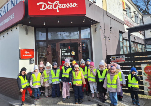 Dzieci stoją przed budynkiem pizzeii