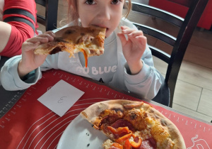 Dziewczynka je pizzę przez siebie zrobioną