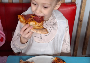 Dziewczynka je pizzę przez siebie zrobioną
