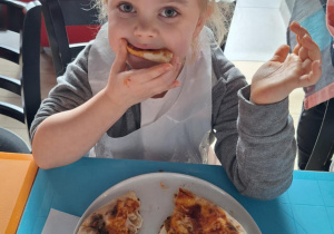 Dziewczynka je pizzę przez siebie zrobioną