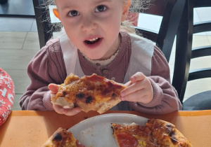 Dziewczynka je pizzę przez siebie zrobioną
