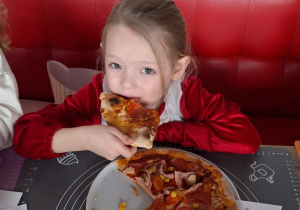 Dziewczynka je pizzę przez siebie zrobioną
