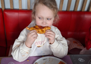 Dziewczynka je pizzę przez siebie zrobioną