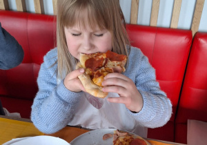 Dziewczynka je pizzę przez siebie zrobioną