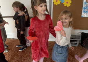 dwie dziewczynki z sercami w dłoni