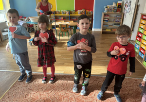 Dzieci przykładają serca do piersi