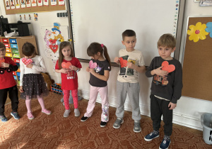 Dzieci przykładają serca do piersi